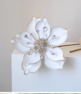 Detail of white velvet magnolia with gold glitter edges and crystal accents for Christmas