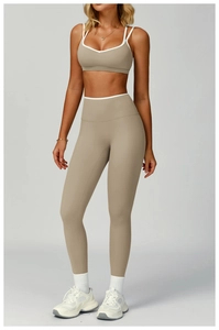 Dettaglio del set yoga taupe con bordini bianchi a contrasto su reggiseno a V e leggings