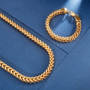 Ensemble collier et bracelet maille Franco dorée pour homme sur fond bleu foncé