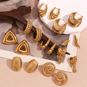 Detailed view of vintage 18K gold-plated stainless steel earrings on a rustic stand