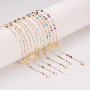 Colorful pearl rosary necklaces with golden metal cross pendants shown on a white pedestal