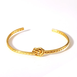 Detailed close-up of 18K gold plated stainless steel knot bracelet with adjustable opening