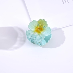 Detailed view of a 4.5cm translucent blue flower hair claw clip with glitter accents
