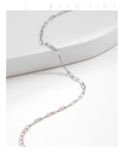 Detailed view of S925 sterling silver paperclip chain bracelet on a white minimalist pedestal