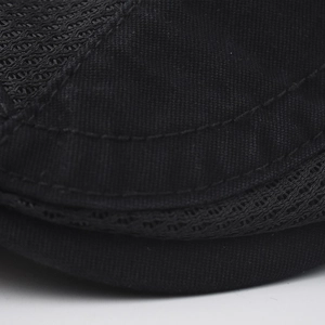 Macro shot of breathable mesh fabric and precise stitching on black cotton beret