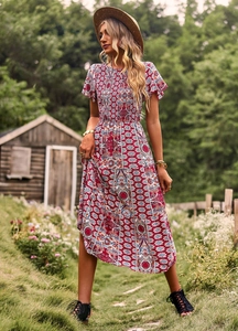 Détail de la robe longue rouge fleurie avec bustier froncé et motifs bohèmes chic