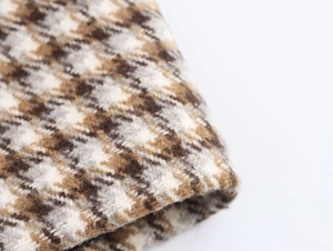 Detail eines Plaid-Wollmantels mit braunen, beigen Mustern und dezenten Goldfäden