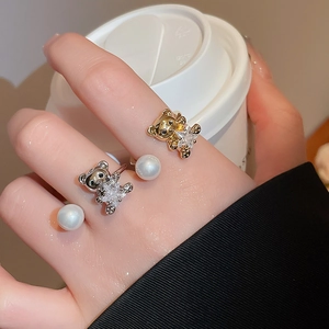 Detail showing bear and star open ring with pearl on model hand