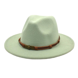 Detail of mint green fedora hat with flat brim and brown leather band with skull buckle