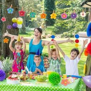Detail showing colorful hibiscus flower cutouts as party banner on outdoor lawn