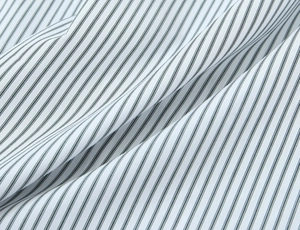 Close-up detail of high-quality striped poplin fabric with elegant drape and fine texture