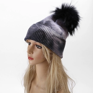 Close-up of ribbed knit texture and purple gradient dye on winter beanie with pompom