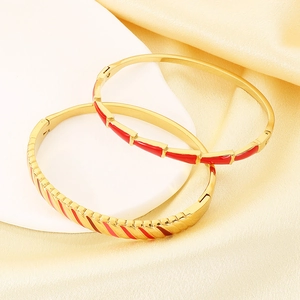 Detailed macro of 18K gold plated stainless steel bangles with red enamel details