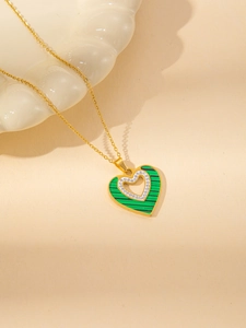 Detail of gold heart pendant necklace featuring green malachite texture and zircon inlay