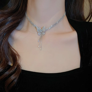 Détail d'un collier papillon argenté avec pampilles en zircons porté par un mannequin