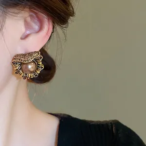 Boucles d'oreilles perles vintage et diamants bruns portées pour un style élégant