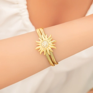 Eleganter Gold-Titanstahl-Armband mit Sonnenstrahl-Anhänger und weißen Rheinkieseln