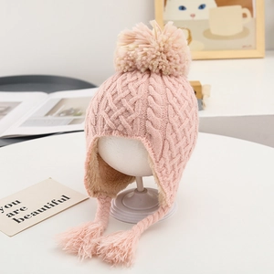 Detail view of pink knit baby hat with warm fleece lining and decorative tassels