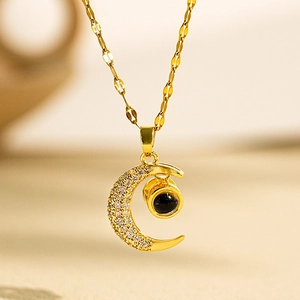 Golden moon pendant necklace with micro diamonds and central black projection stone