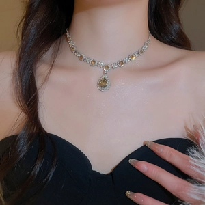 Detailed close-up of luxurious necklace featuring yellow teardrop gemstone and silver diamonds