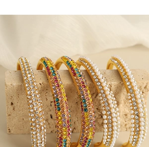 Detailed close-up of 5 gold-plated bracelets featuring white pearls and colorful rhinestones
