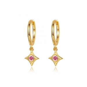Detailed close-up of gold star earrings featuring centered pink zircon gemstones