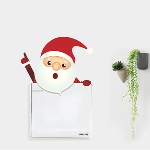 Close-up of a Santa Claus wall sticker decorating a white Philips light switch panel