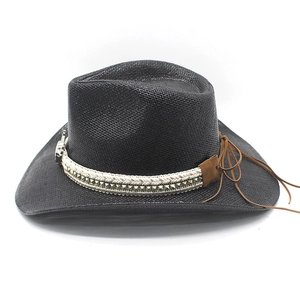 Detail of black straw cowboy hat featuring silver studs and brown leather drawstring