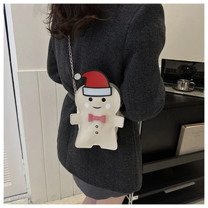 Crossbody gingerbread man bag with red Santa hat and metal chain on a model