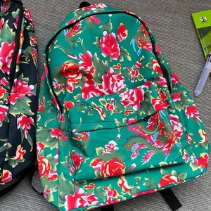 Detailed view of traditional Chinese floral pattern backpacks with front zipper pockets