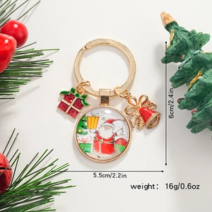 Détails d'un porte-clés de Noël avec Père Noël, boîte cadeau et clochette dorée
