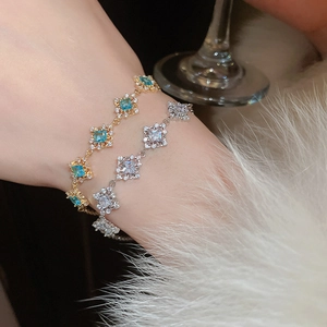 Detail of luxury geometric square zircon bracelets in gold and silver on fur background