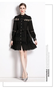 Detail of black long-sleeved lace dress featuring hollow-out patterns and button-up front