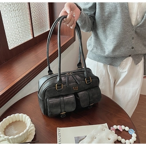 Close-up of vintage dark grey bowling bag with front pockets and bronze hardware detail
