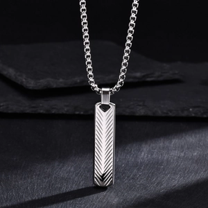 Detailed view of silver titanium pendant featuring geometric V-shape textured pattern