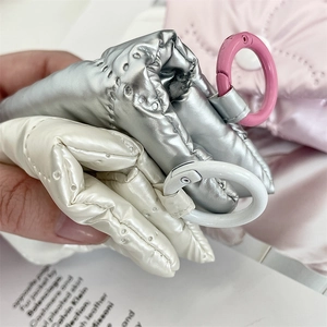 Close-up of metallic silver and white quilted ribbon pouches with round spring hooks