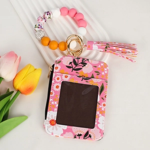 Pink floral card wallet with silicone beaded bracelet, tassel and ID window detail