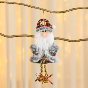 Plush Santa ornament with plaid hat and bells hanging on a wooden branch decor