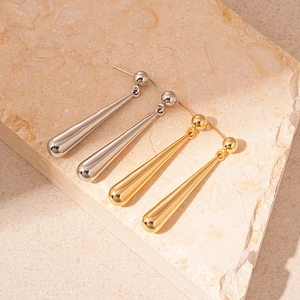 Minimalist gold and silver teardrop earrings on textured stone background for women