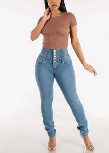Detailed view of high waisted skinny jeans with multi-button closure and elastic waist seal