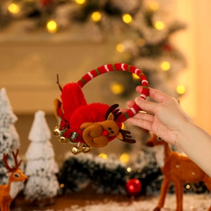 Detail of red plush Christmas earmuffs with cute reindeer antlers and small metal bells