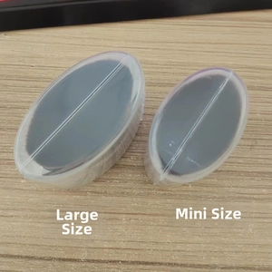 Macro detail of large and mini oval foundation brushes with clear protective cases on wood