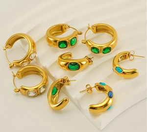 Gros plan de boucles d'oreilles créoles vintage plaquées or 18 carats avec émeraudes