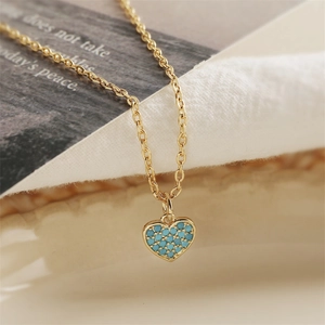 Golden heart pendant necklace with turquoise stones shown in a professional macro shot