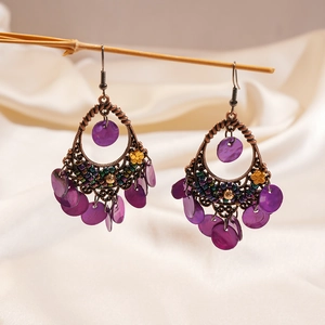 Bohemian drop earrings with purple shells and vintage bronze finish on wooden branch