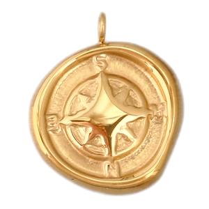 Macro detail of a golden compass pendant featuring N, S, E, W letters and star design