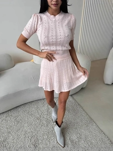 Ensemble deux pièces en tricot rose avec haut au crochet et mini-jupe plissée à taille haute
