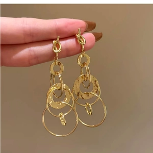 Gold interlocking circular drop earrings with textured finish and elegant knotted top design