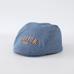 Detailed close-up of blue denim flat cap featuring brown Boston 1630 embroidery