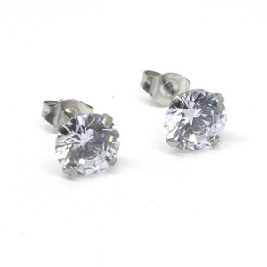 Détail macro de boucles d'oreilles argentées à quatre griffes avec zircons ronds